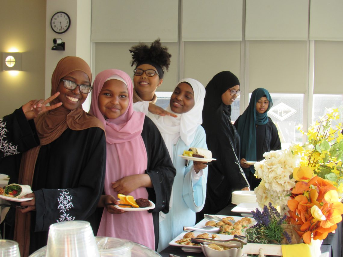 TRIO students smile in a buffet line at our annual graduation celebration.