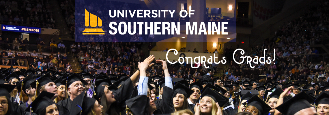 Graduates at their commencement ceremony hitting a beach ball into the air with the University of Southern Maine logo top and center with the text congrats grads underneath