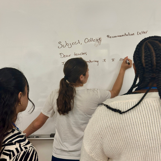 UB students write on a white board.