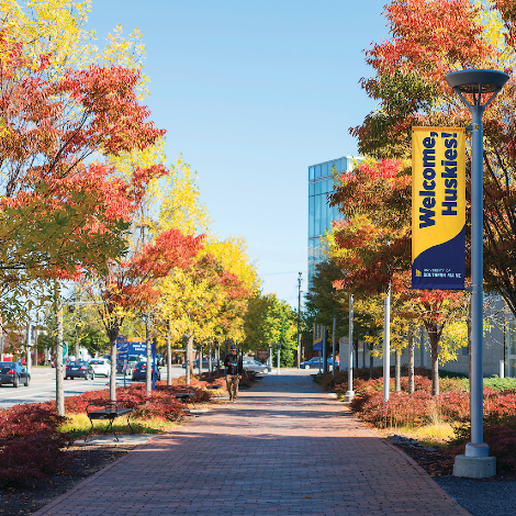 USM Portland campus in the fall with a "Welcome, Huskies!" sign