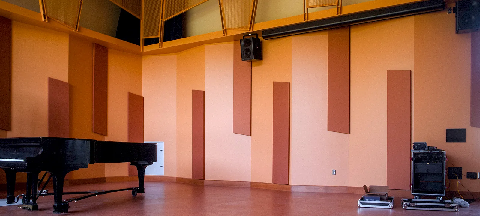 A Steinway Baby Grand piano sits alone in the Crew Center Rehearsal Hall.