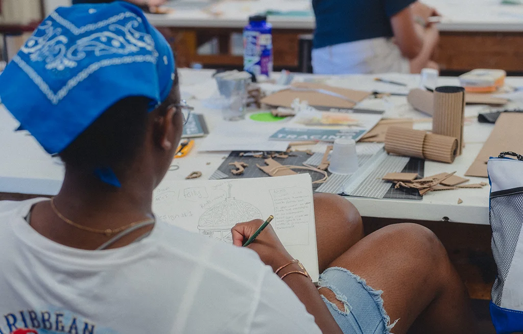 A student draws at a table during an art class.