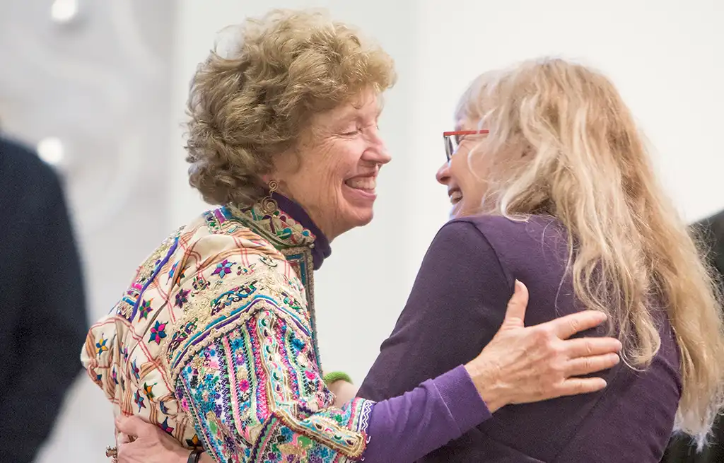 Two patrons embrace at an exhibit opening in the Atrium Gallery.