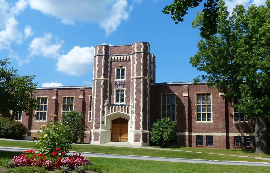 Russell Hall on a sunny day with fluffy clouds in the sky.