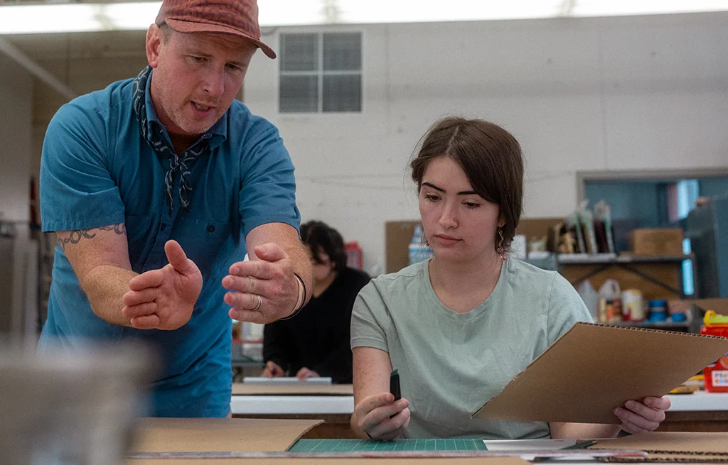 A faculty member and student engaged in a discussion.