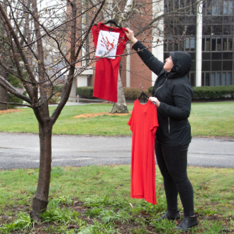 Dr. Ashley Towle endured cold and rain to hang dresses for the REDress Project.