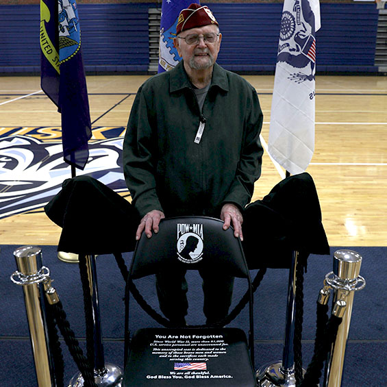 Leon Tanguay, a prisoner of war during World War II, poses with the Chair of Honor.