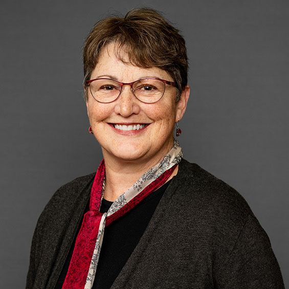 A headshot of Dr. Susan Noyes against a dark backdrop.