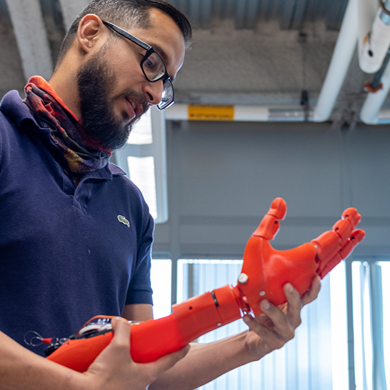 Assistant professor Asheesh Lanba holding a prosthetic arm prototypes he helped develop in our MIST lab.