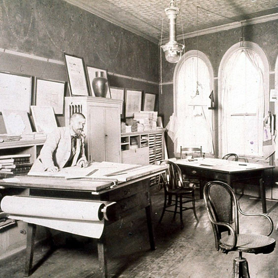 A black and white photo of architect John Calvin Stevens in his Portland, ME office circa 1890. Photo courtesy of SMRT Architects and Engineers.