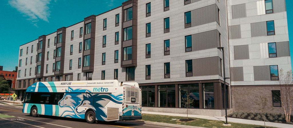 A Husky Line METRO bus passes in front of our Portland Commons residence hall on Bedford Street in Portland, Maine.