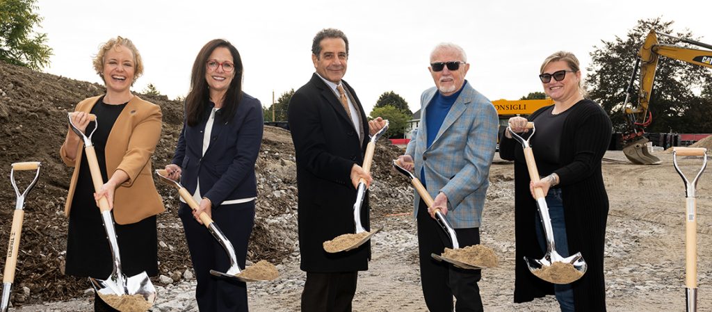 A group of five people holding up shovelfuls of dirt. From left to right, Ainsley Wallace, President Jacqueline Edmondson, Tony Shalhoub '77, Dan Crewe ’22H, and Reid Crewe.