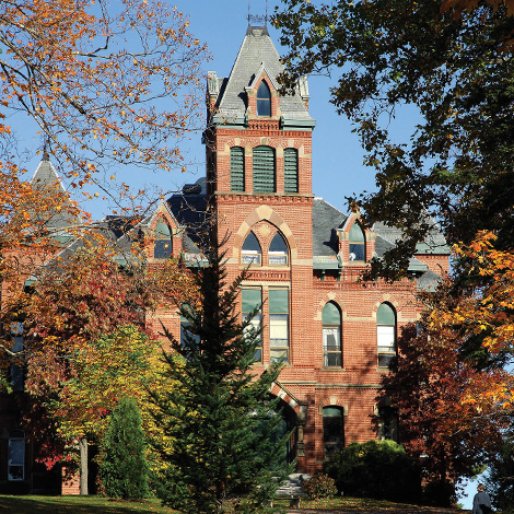 Corthell Hall surrounded by bright foliage on a bright autumn day.