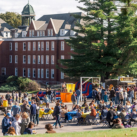 A crowd of people outside of Robie-Andrews Hall enjoying a Homecoming and Family Weekend event.