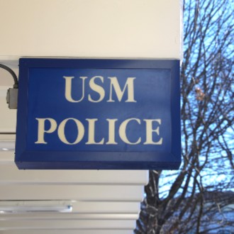 A sign indicates that the offices of the USM Police can be found inside Sullivan Gym in Portland.