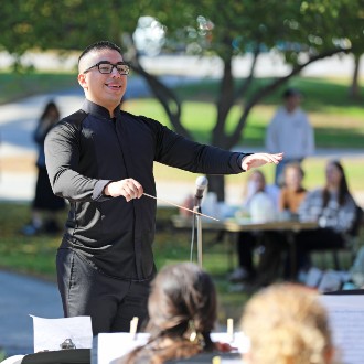 Justin Conley-Reyes conducts Stars and Stripes Forever as the closing number of the Osher Wind Ensemble's annual homecoming concert.