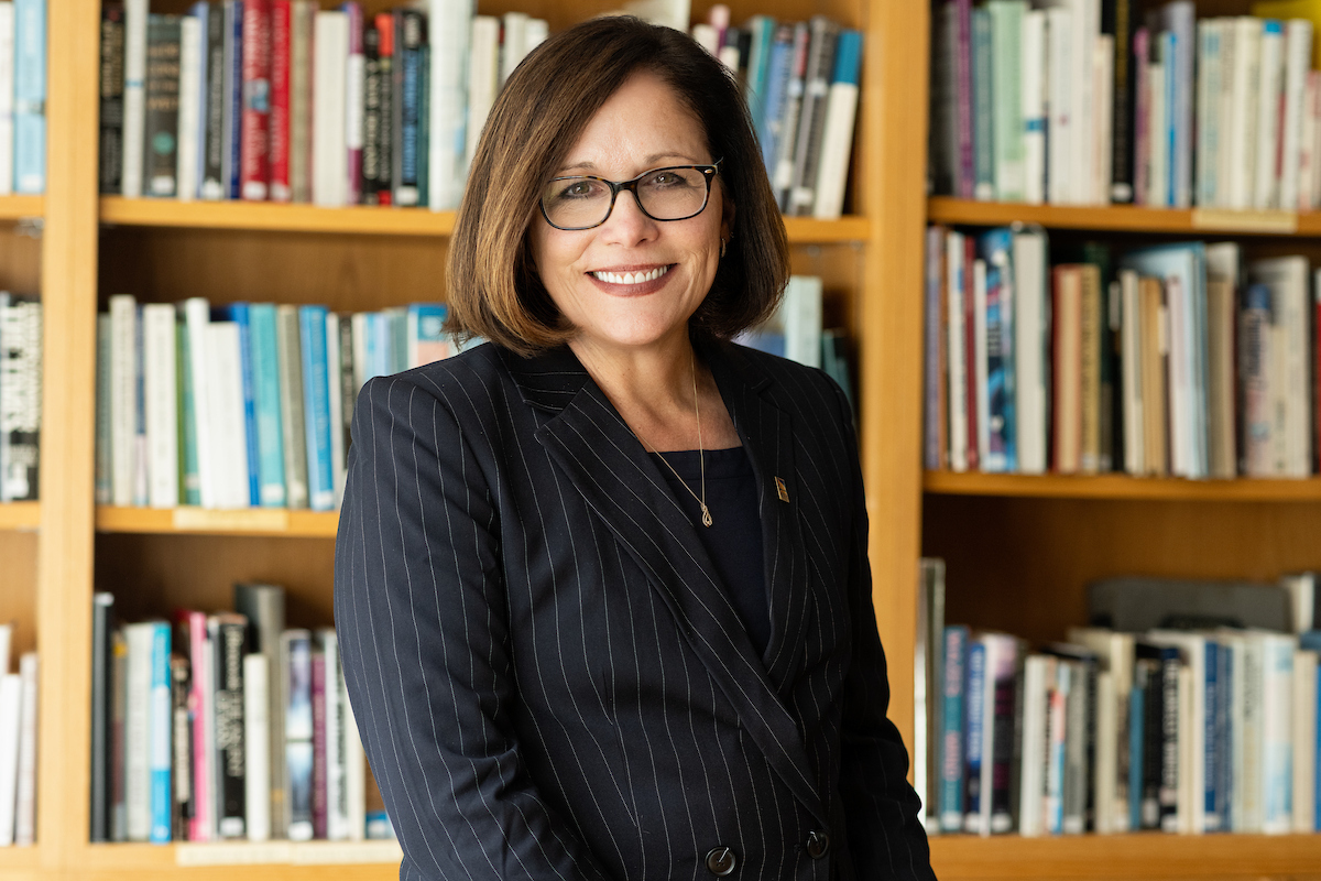 Jacqueline Edmondson posed in front of book shelf.