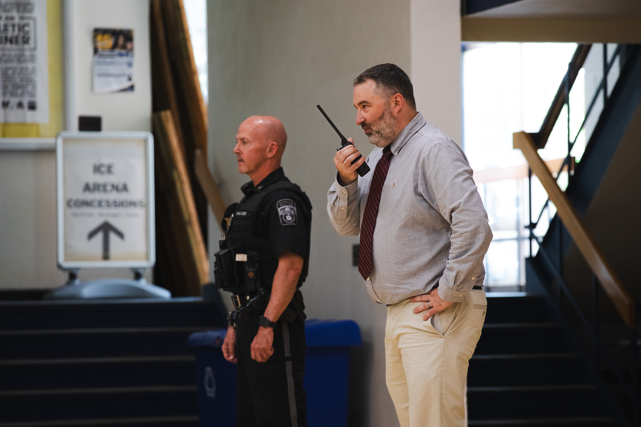 An officer and an administrator coordinate over radio during USM's school reunification exercise.