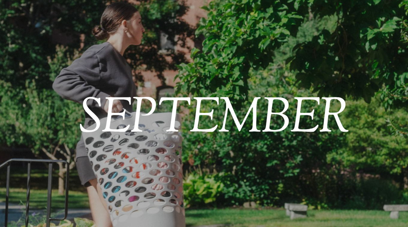 The word "SEPTEMBER" in white text overlaid on a student carrying a laundry basket outdoors on campus